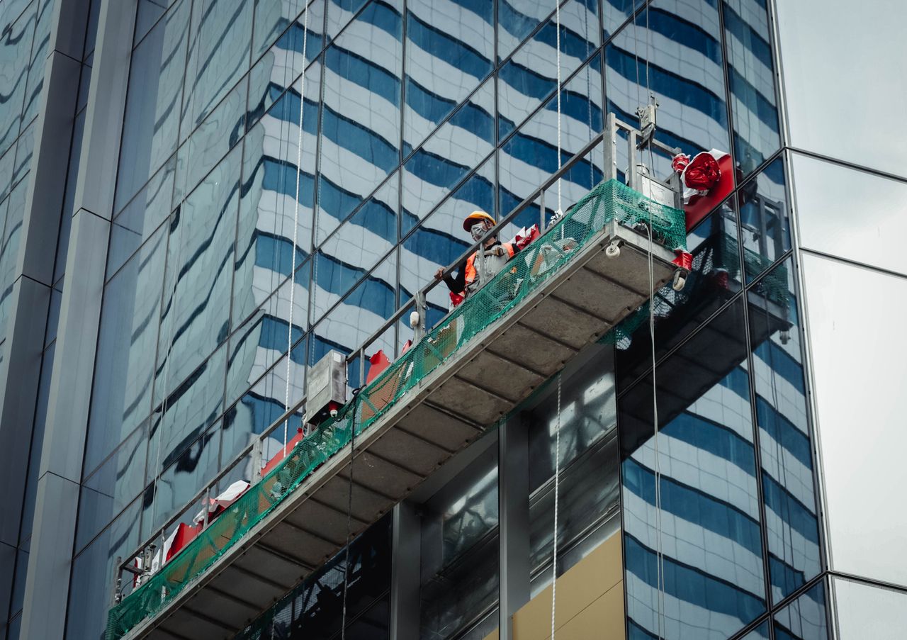 team-04 Urban worker cleaning windows on a high-rise in Ho Chi Minh City, Vietnam.